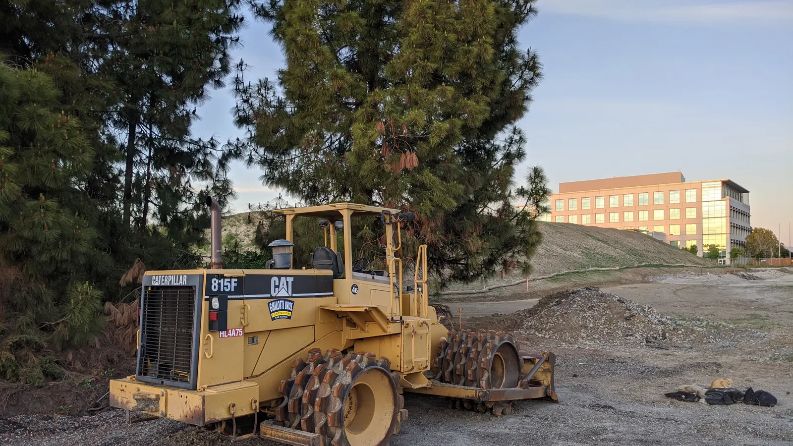A soil compactor working over placed fill on a construction site