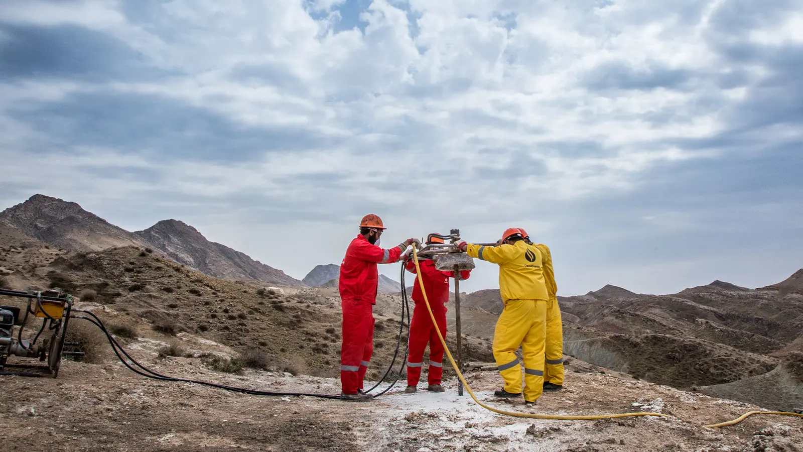 A drilling crew operating a geotechnical rig on rocky ground