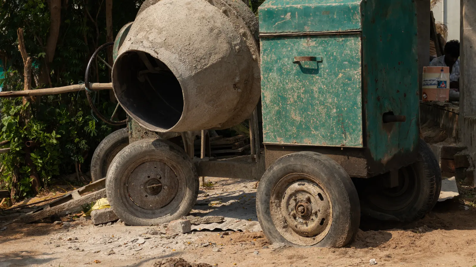 A small drum concrete mixer standing on a building site