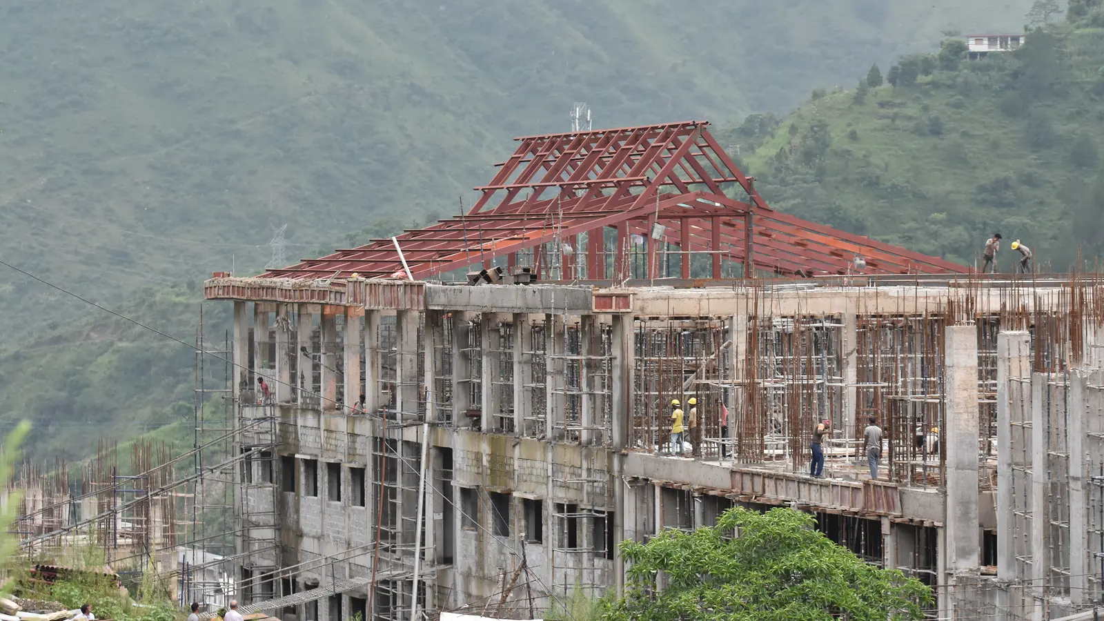 A steel roof frame being erected on a multi-storey concrete building