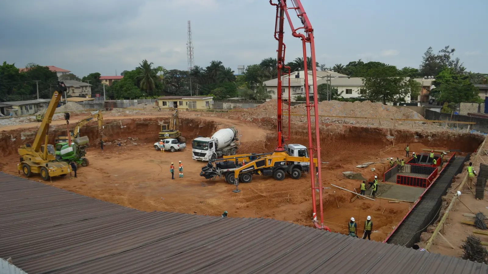 Concrete mixer trucks and a pump on a large excavated building site