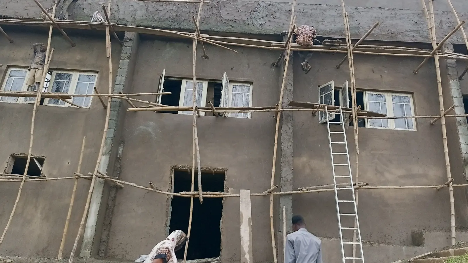 Improvised timber scaffolding on the plastered facade of a building under construction