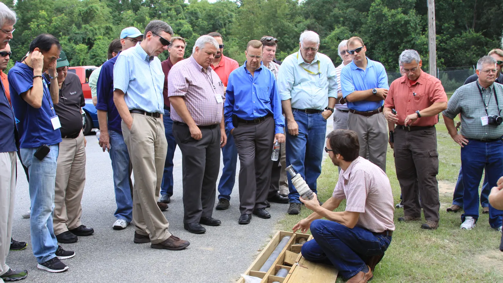 A geologist showing a box of soil core samples to a group of engineers