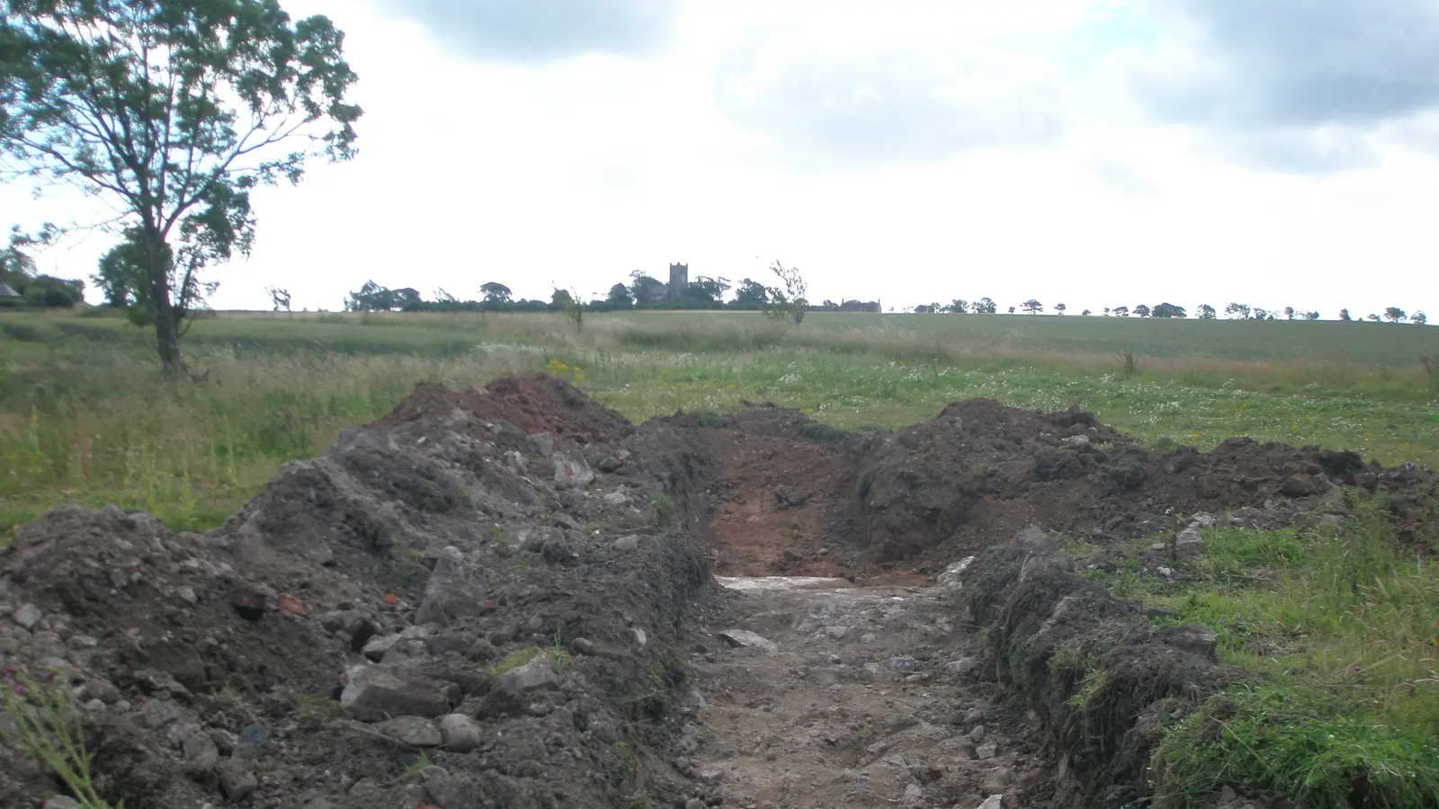 A freshly dug trench across a field